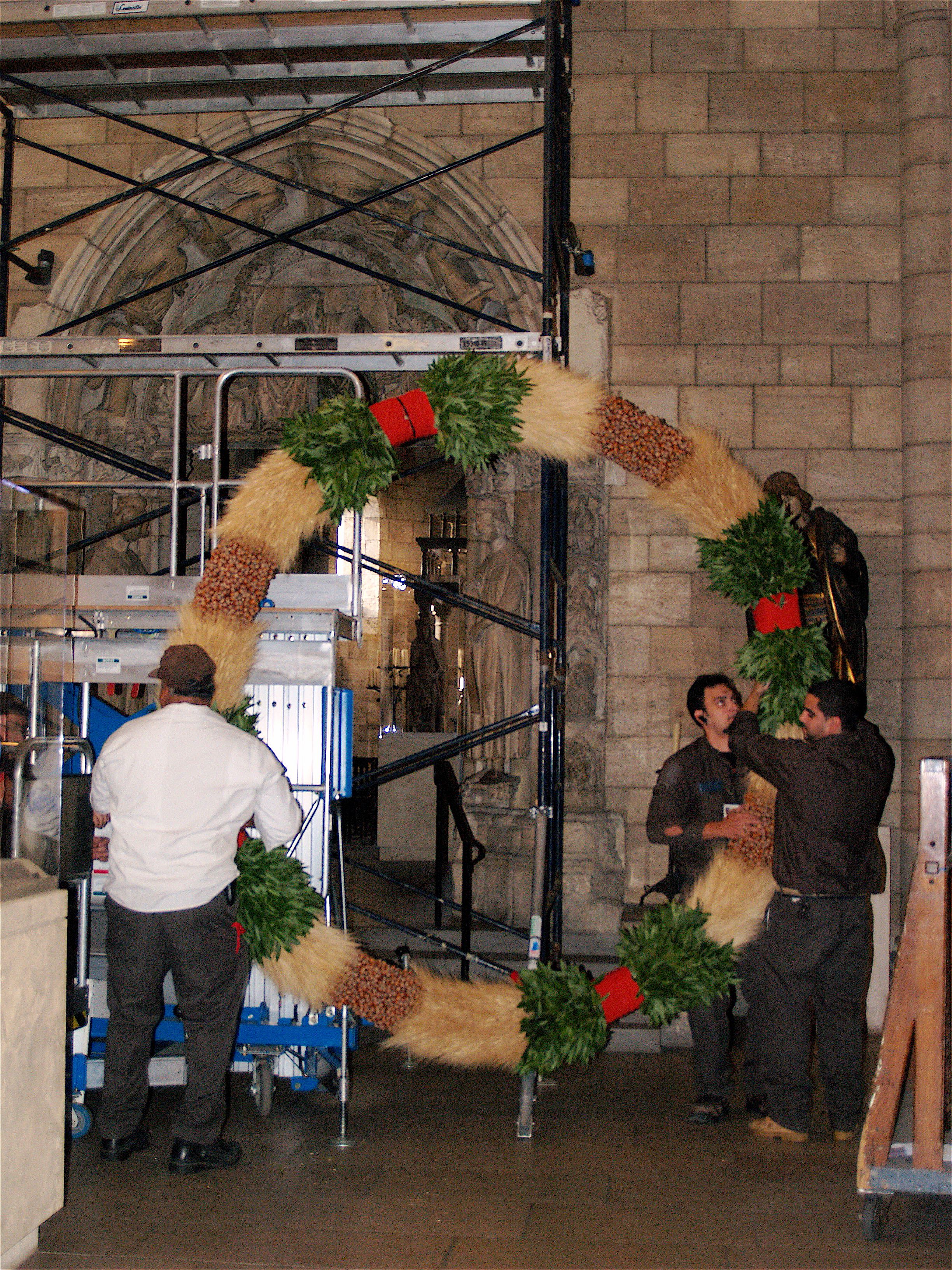 Preparing to hang the wreath in the Romanesque Hall.